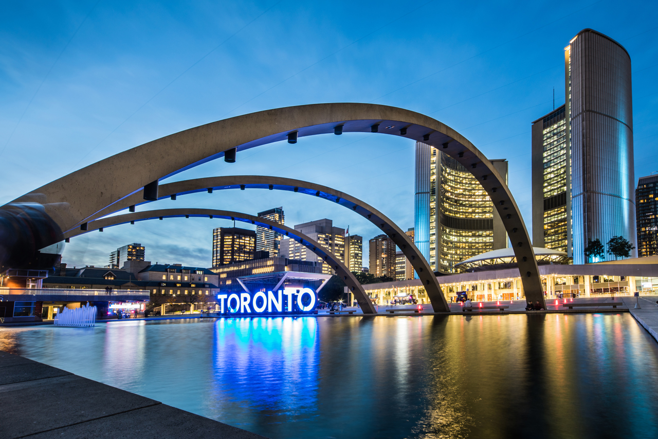 Nathan Phillips Square and City Hall lit up at night.