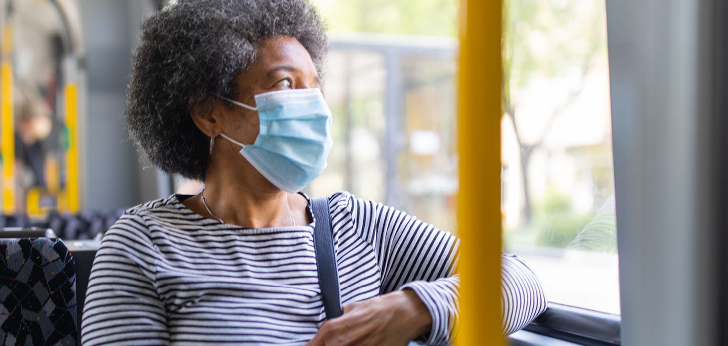 Masked woman on public bus.