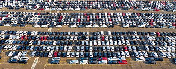 A sea of cars parked in manufacturers lot.