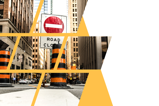 A closed road with signage and pylons