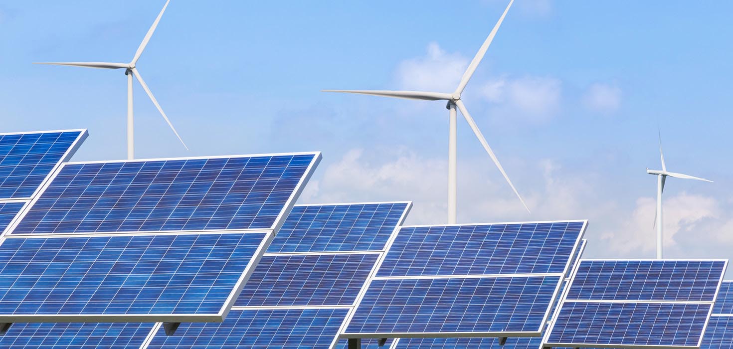 Solar panels and wind turbines on a blue sky.