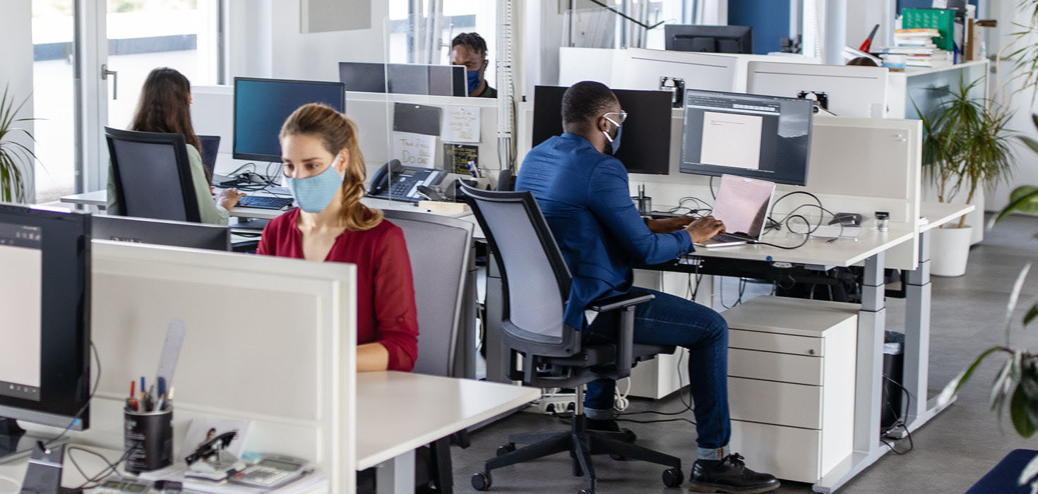 Masked employees working in an office.