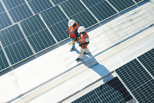 Two engineers walking amongst solar panels.