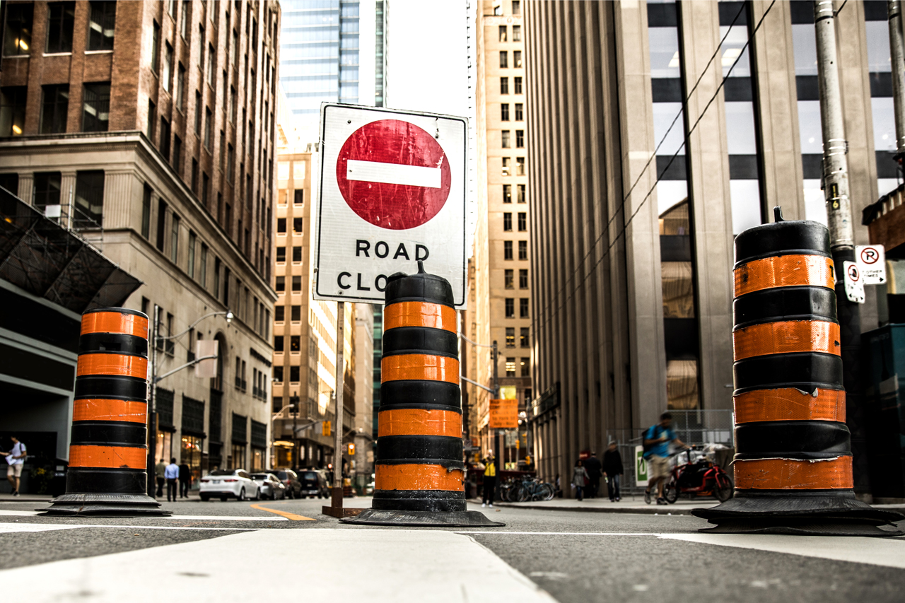 A closed road with signage and pylons